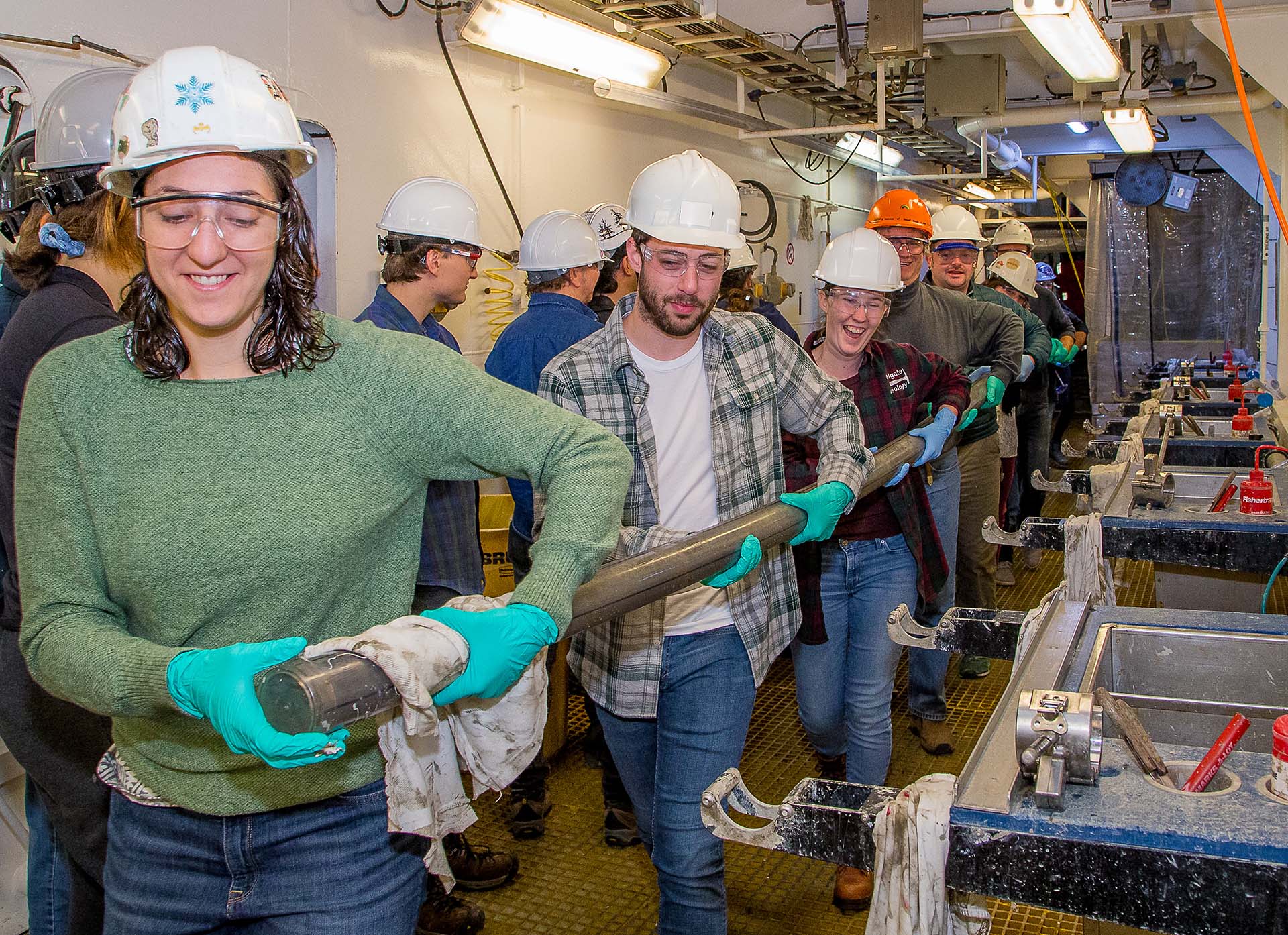 8 people holding long cores.